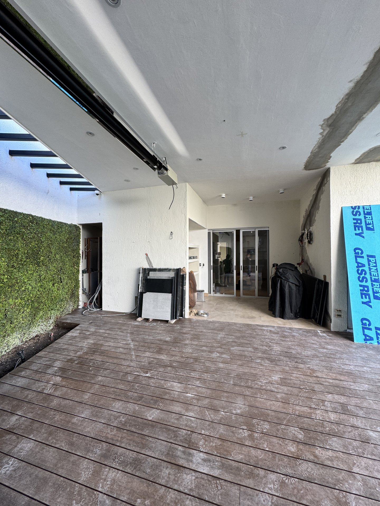 Terraza cubierta con pérgola y muro verde — Cachay